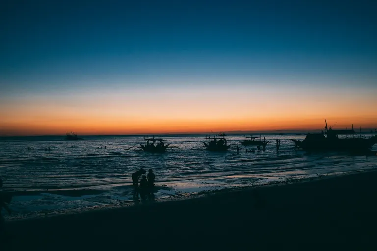 Fishermen by the shore before sunrise